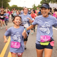 Mother and daugther holding hands while running the 5K